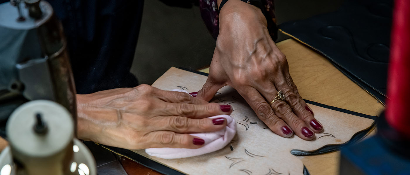 Women works on leather for boots